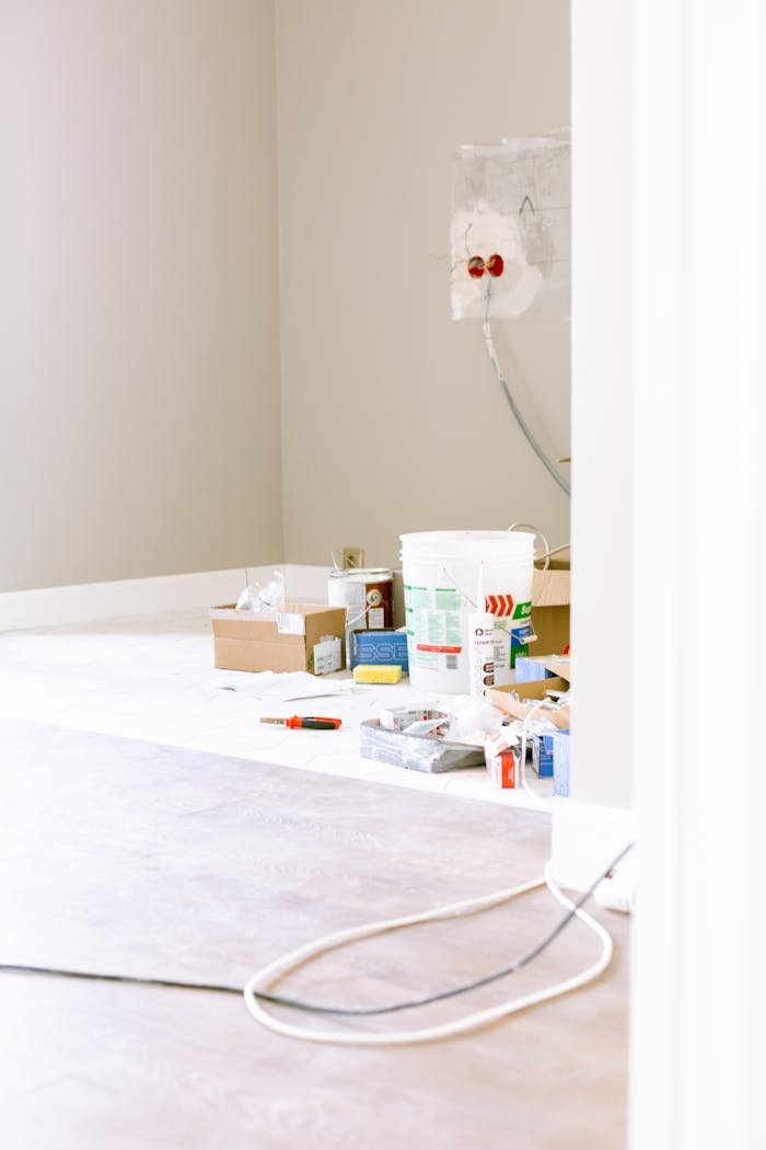 A room corner with renovation supplies, paint cans, and tools, ready for a home improvement project.
